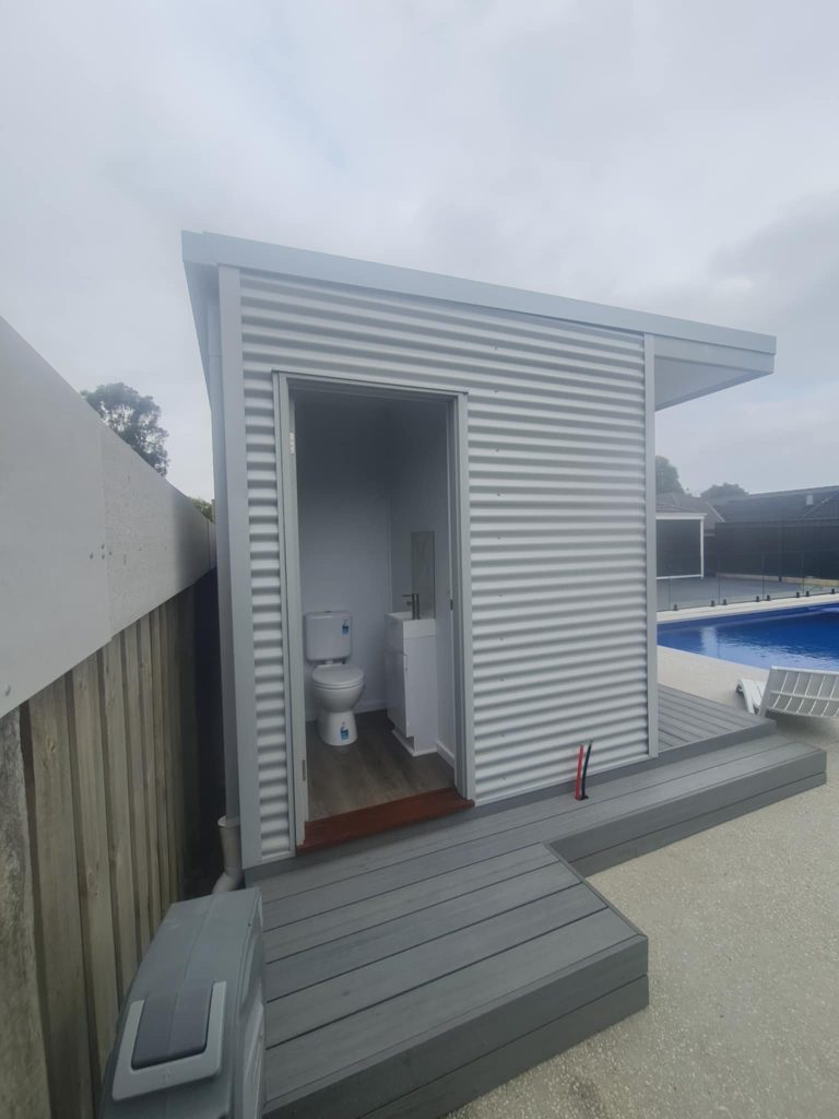 Compact poolside amenity building with contemporary corrugated exterior finish